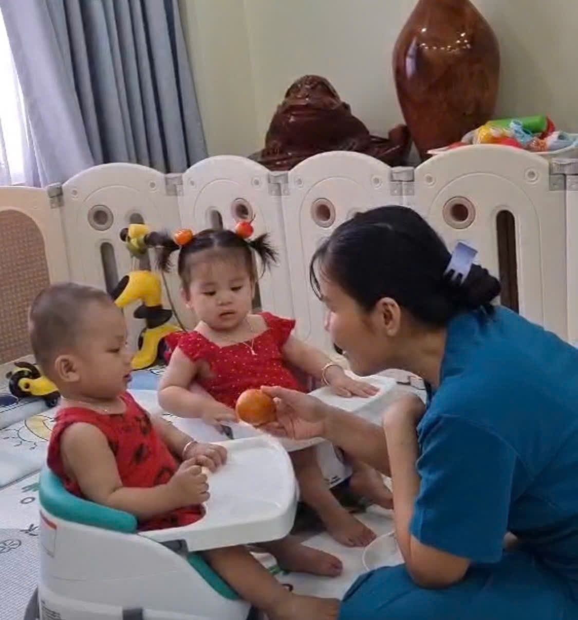 Bảo mẫu Be Care đút cam cho bé gái trong khung vui chơi