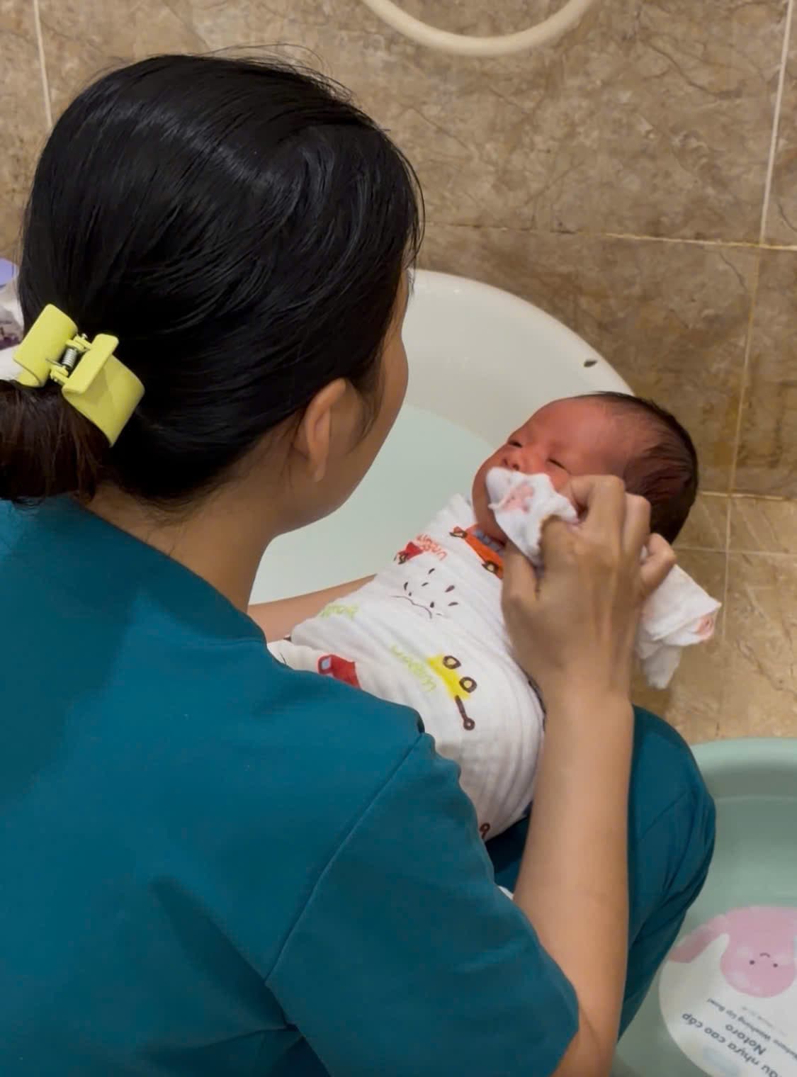 Chuyên viên Be Care lau sạch mặt bé sau khi tắm
