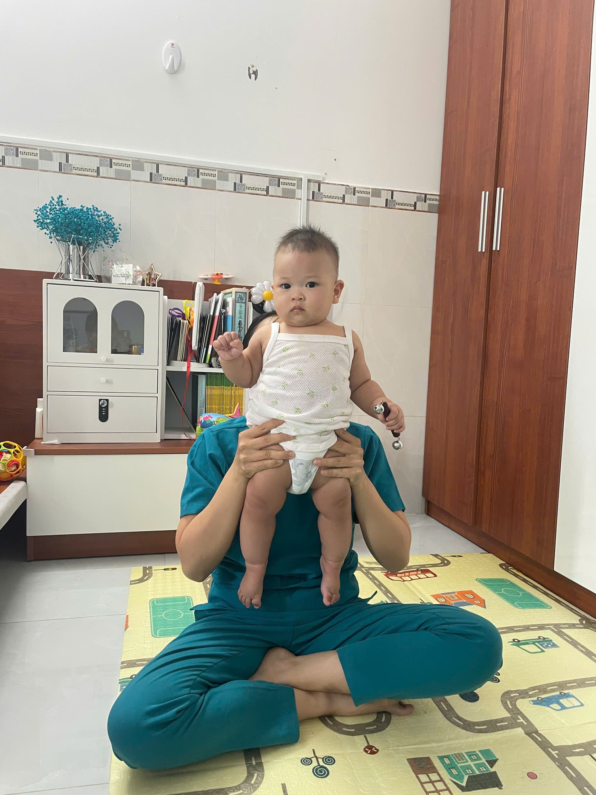 Bảo mẫu Be Care nâng bé lên giúp bé vận động và tương tác